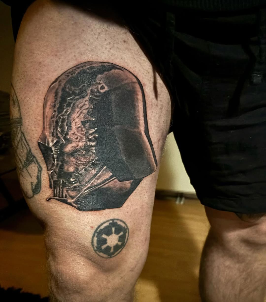Thigh piece depicting Darth Vader's helmet split to reveal Anakin Skywalker's scarred face beneath, with the Imperial crest tattooed below.